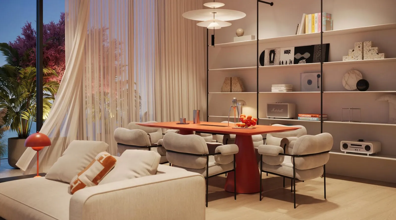 A living and dining room in cream and terracotta, a round red dining table beside built-in shelving