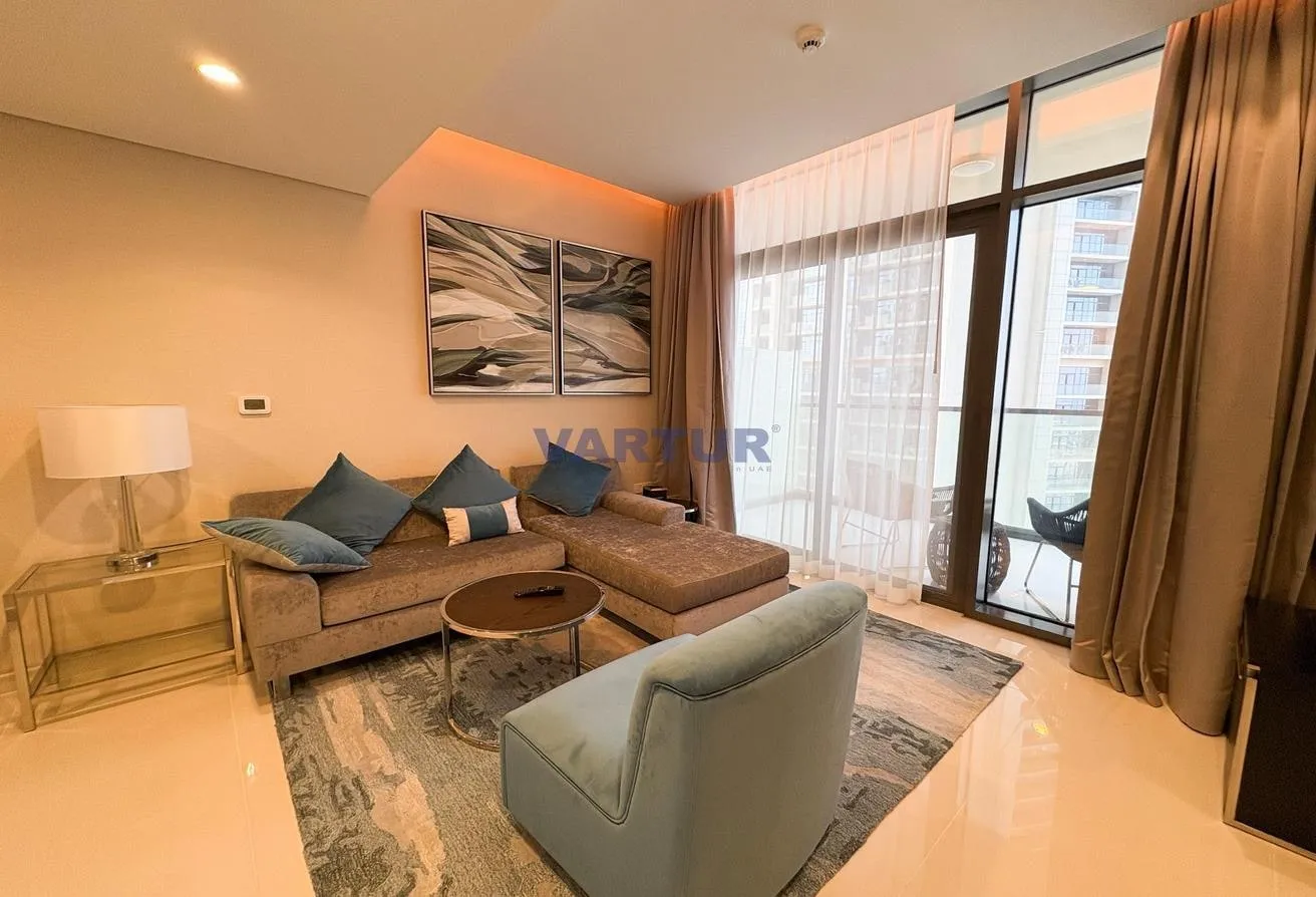 Photo of the furnished living room, with an L-shaped sofa and floor-to-ceiling windows