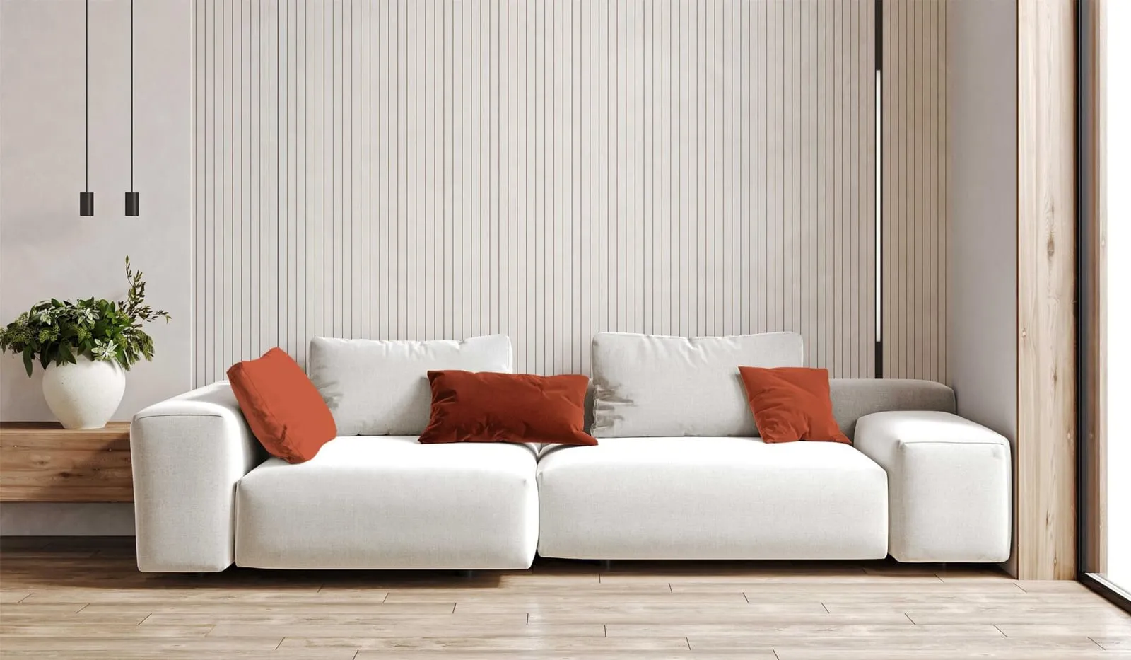 A white modular sofa with rust cushions against a fluted wall panel, a plant standing beside it