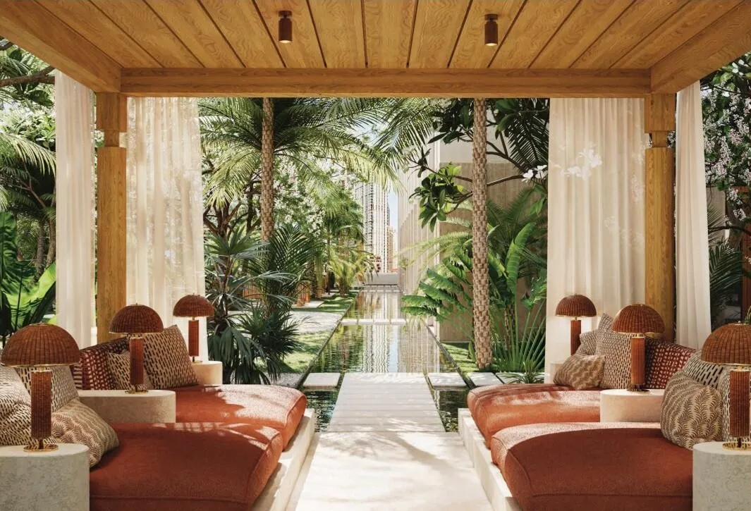 A shaded loggia with day beds on both sides of a narrow water channel running to the planting beyond