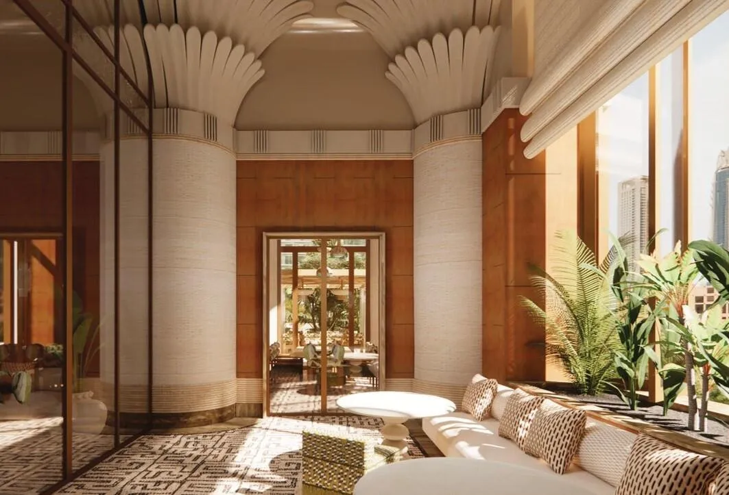 A lounge behind arched openings, low seating and indoor planting under a vaulted plaster ceiling