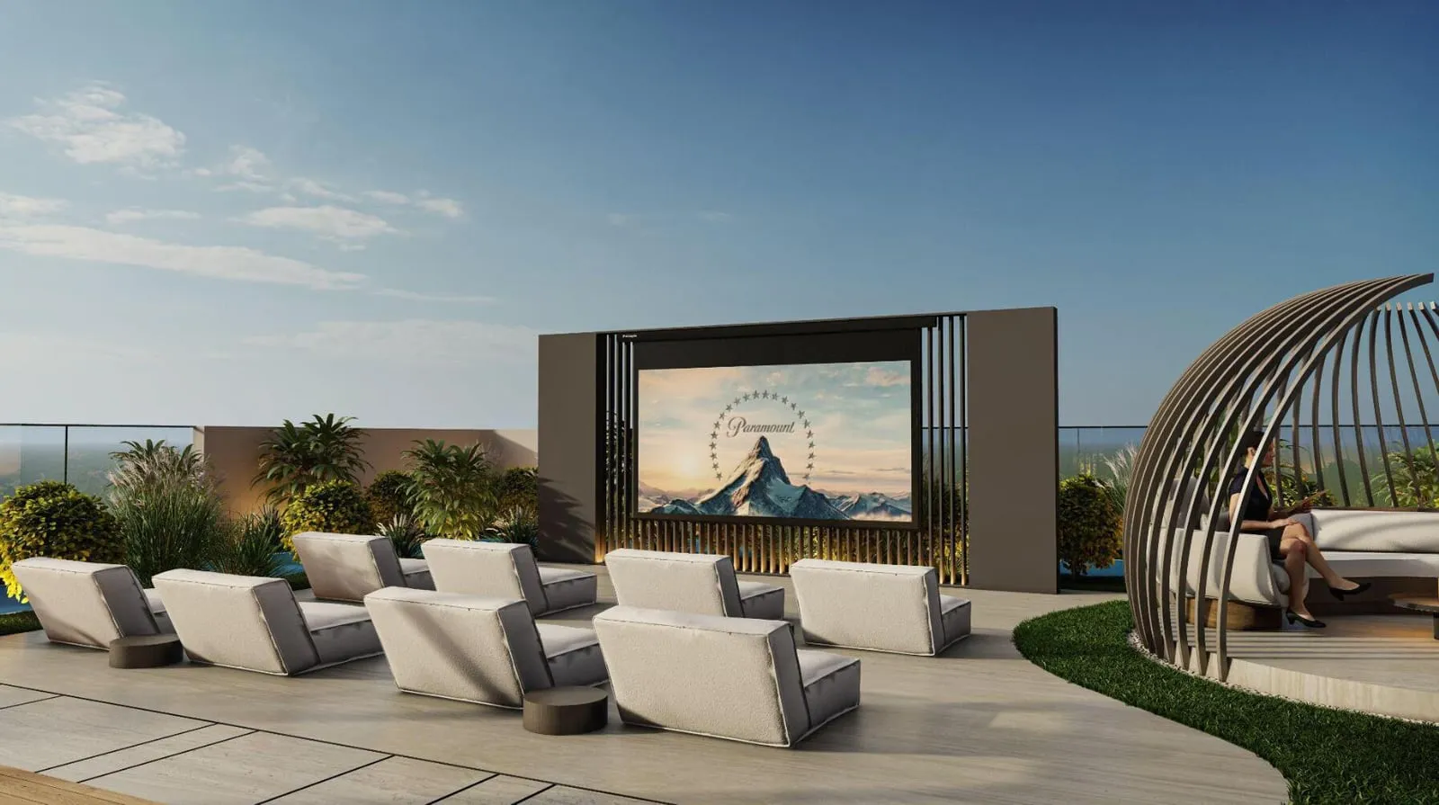 An outdoor cinema deck with rows of lounge chairs facing a large screen