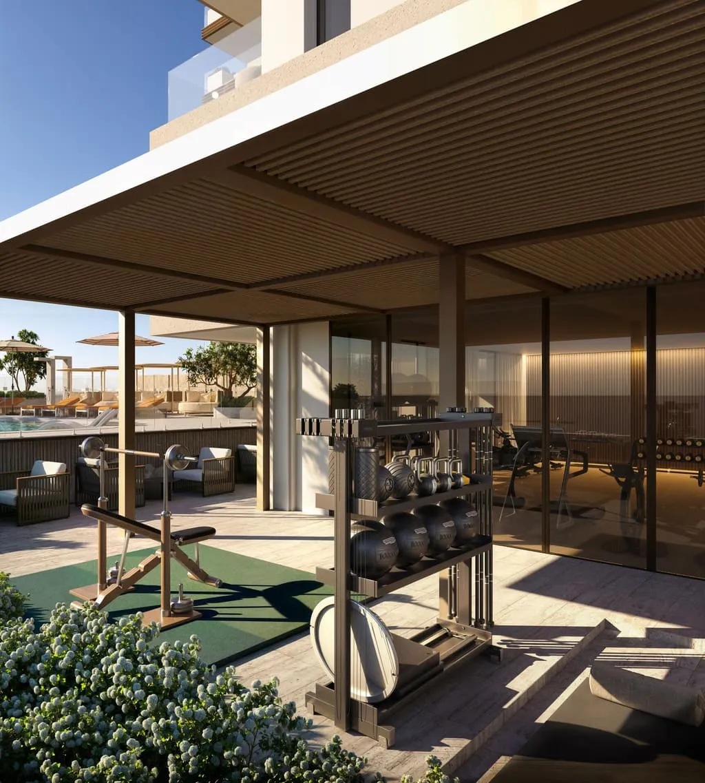 A covered outdoor training terrace, free weights and a rack between planters open to the daylight