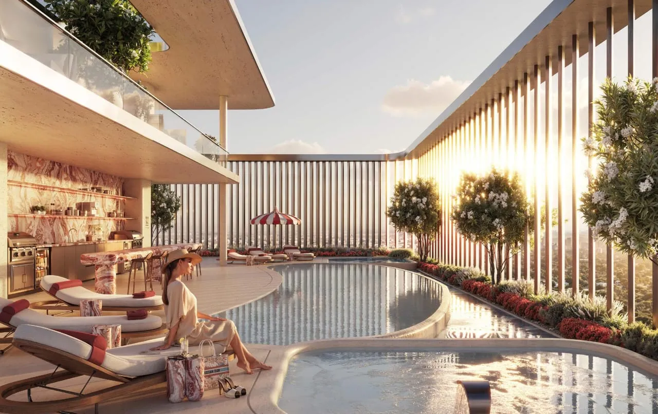 The pool at sunset with a bar under the canopy and flowering trees along the bronze screen
