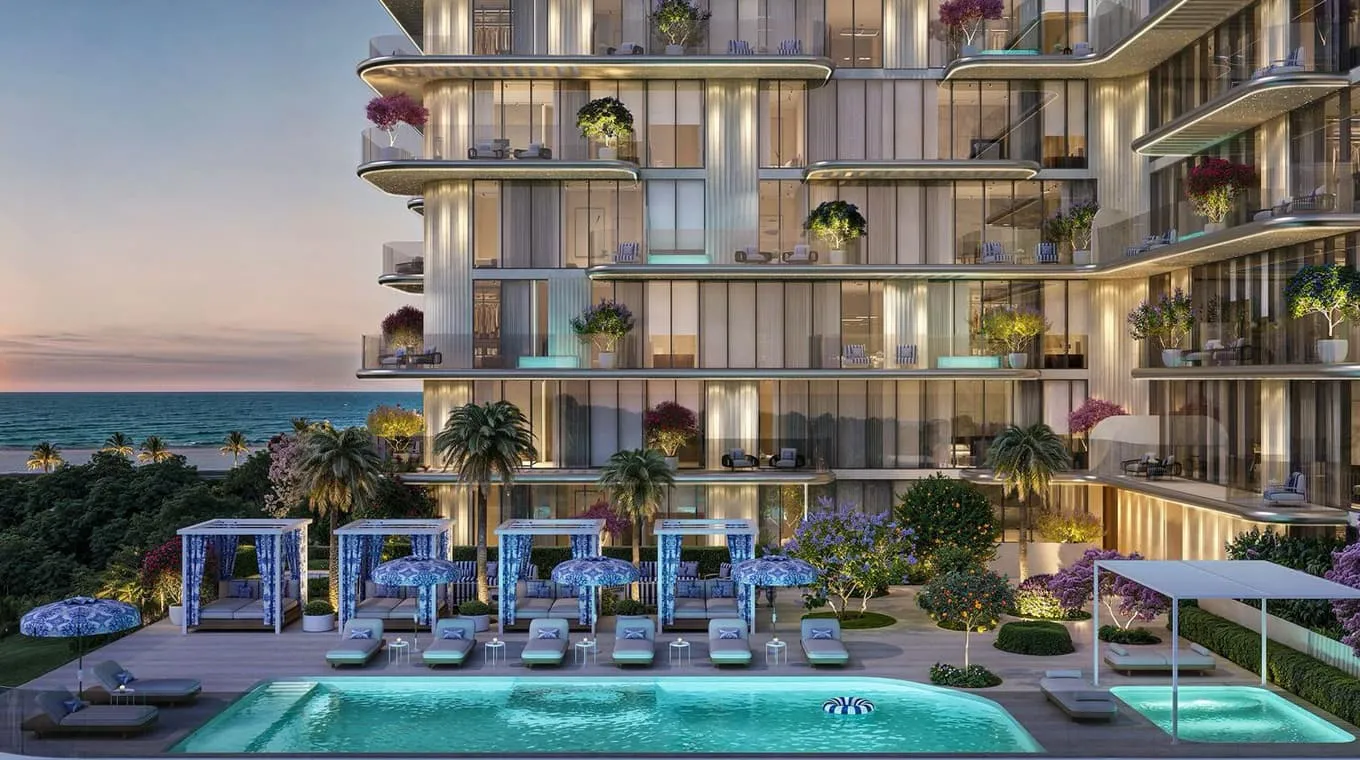 The pool deck at dusk, sunbeds along a turquoise pool under the building's planted, glazed terraces