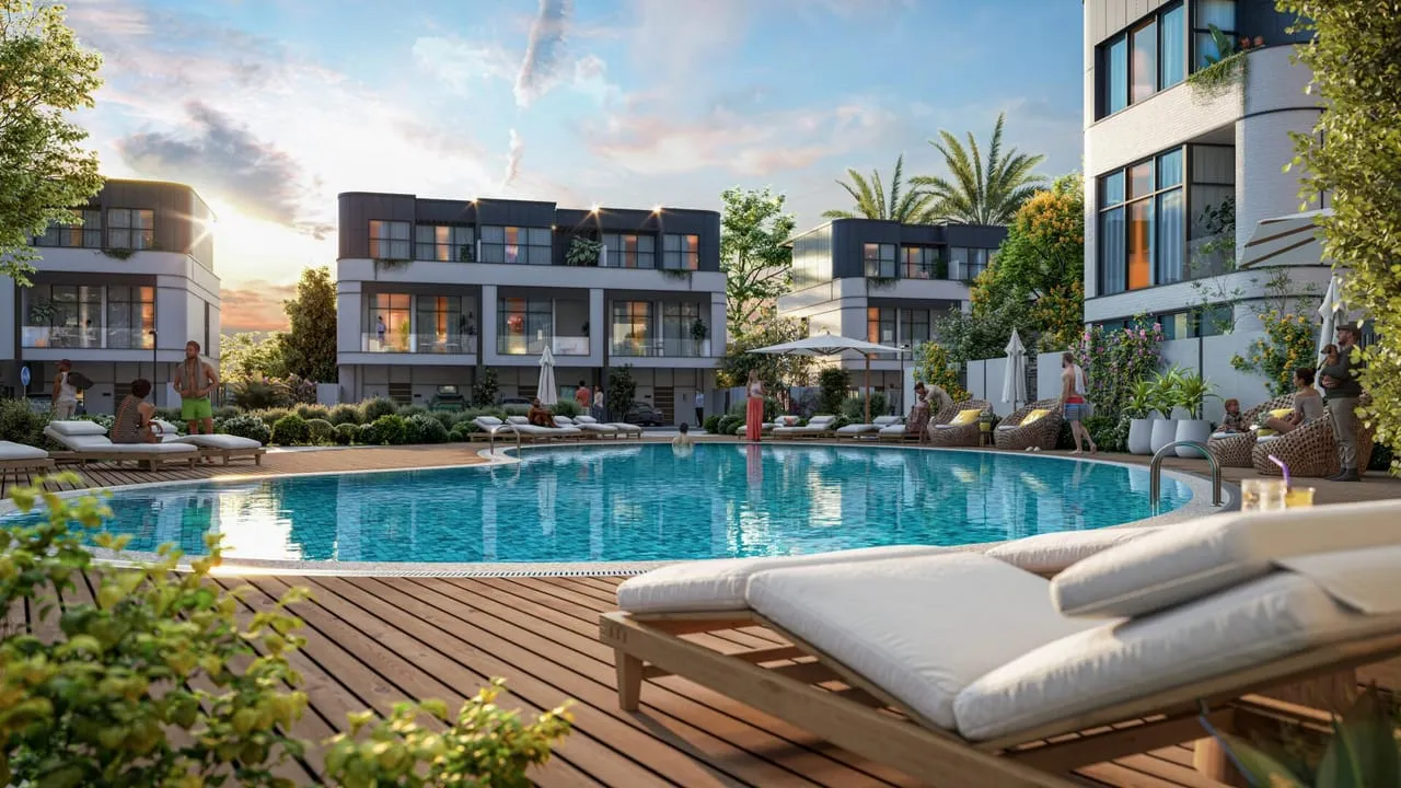 Sun loungers on the Taormina Village pool deck with townhouses behind