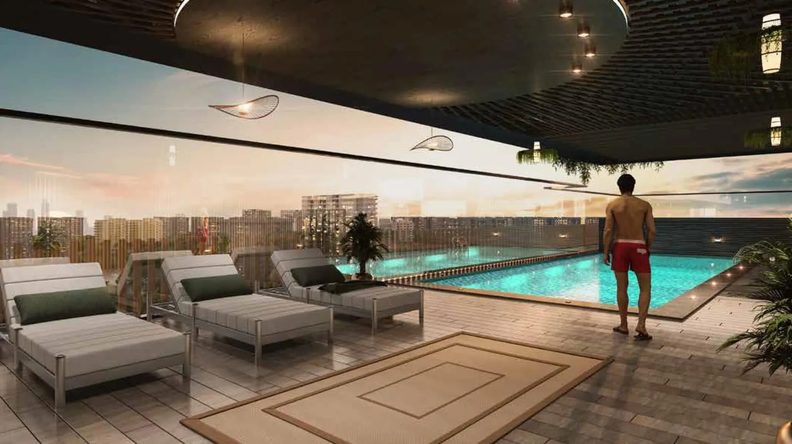 Sun loungers on the pool deck at dusk, a swimmer at the water's edge and the neighbourhood lights beyond