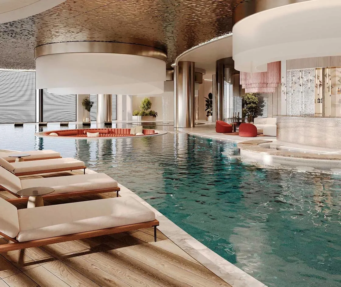 The pool curving past timber loungers, the water lit turquoise under a sculpted ceiling