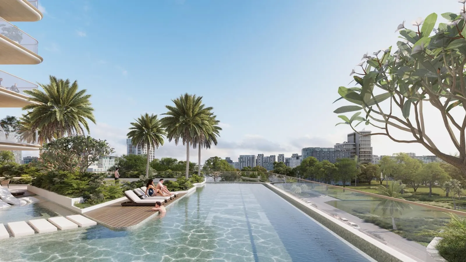 The long pool seen down its length, palms and loungers to both sides and the city low on the horizon