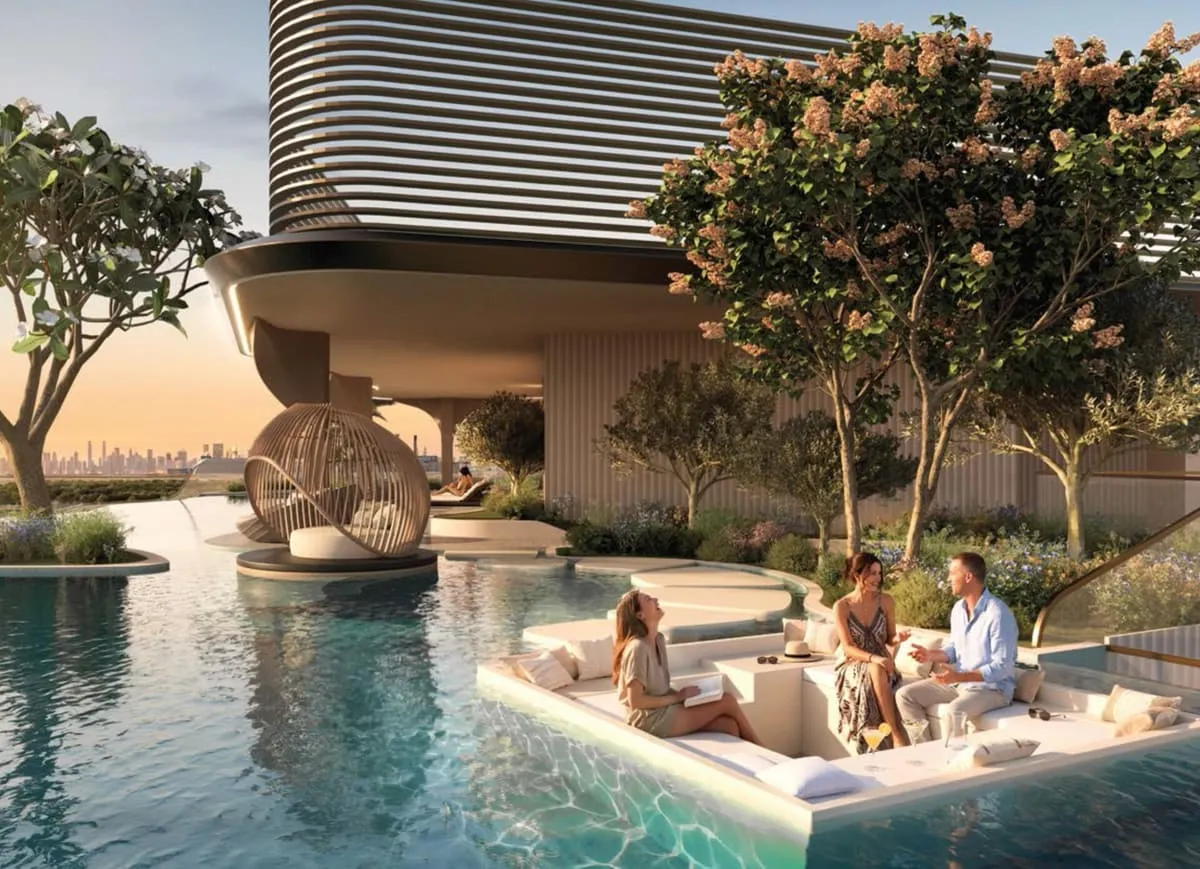 The pool at the building's foot, a sunken seating island in the water and a woven cabana on its own platform