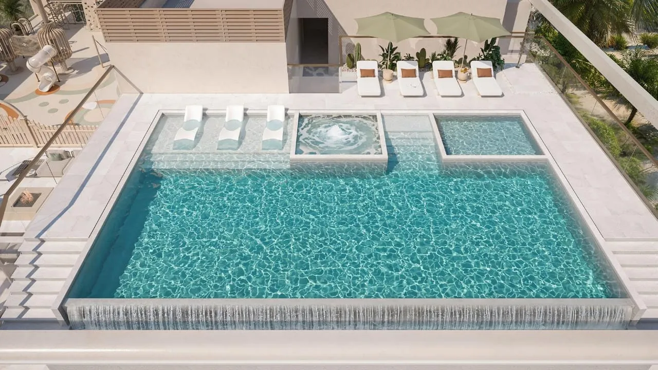 An aerial view of the rooftop pool with a circular fountain feature and sun loungers along its edge