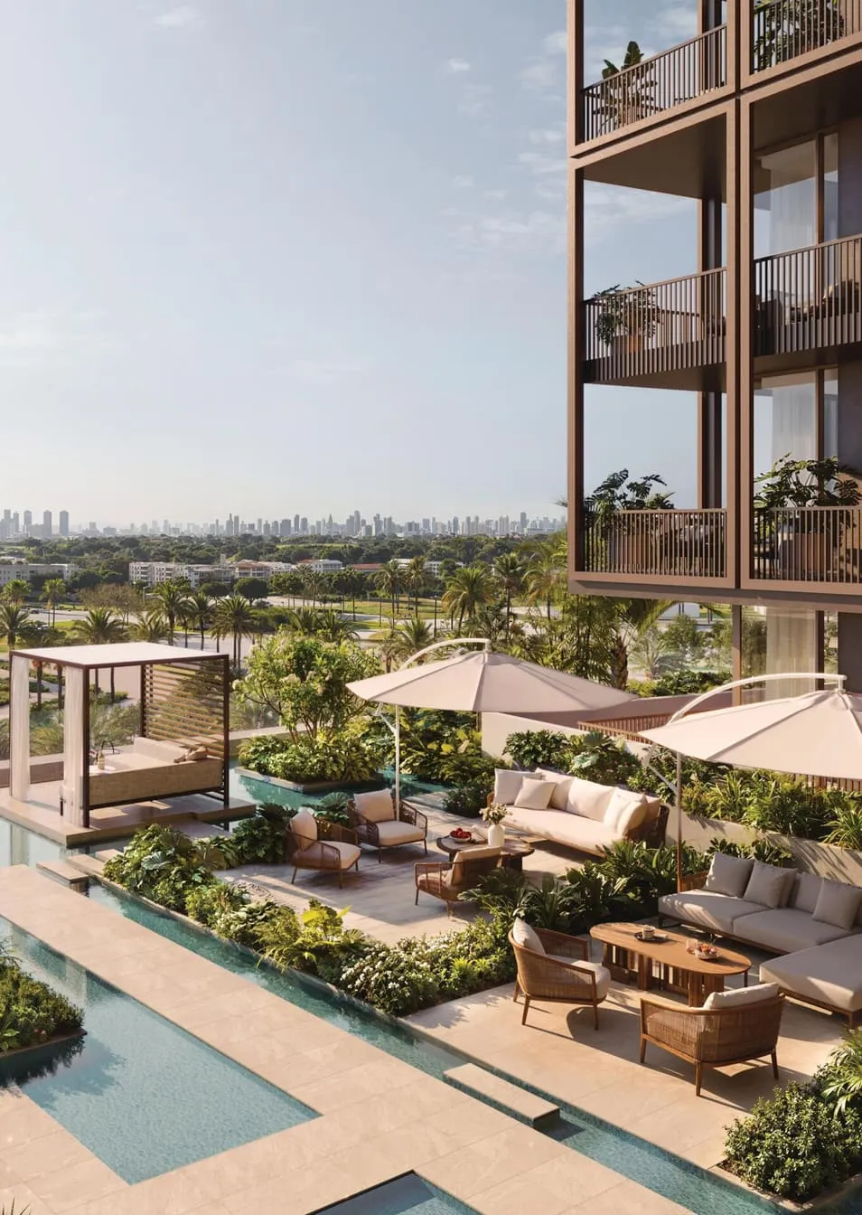 The pool terrace from above, parasols and seating among planting with low-rise houses and a distant skyline beyond