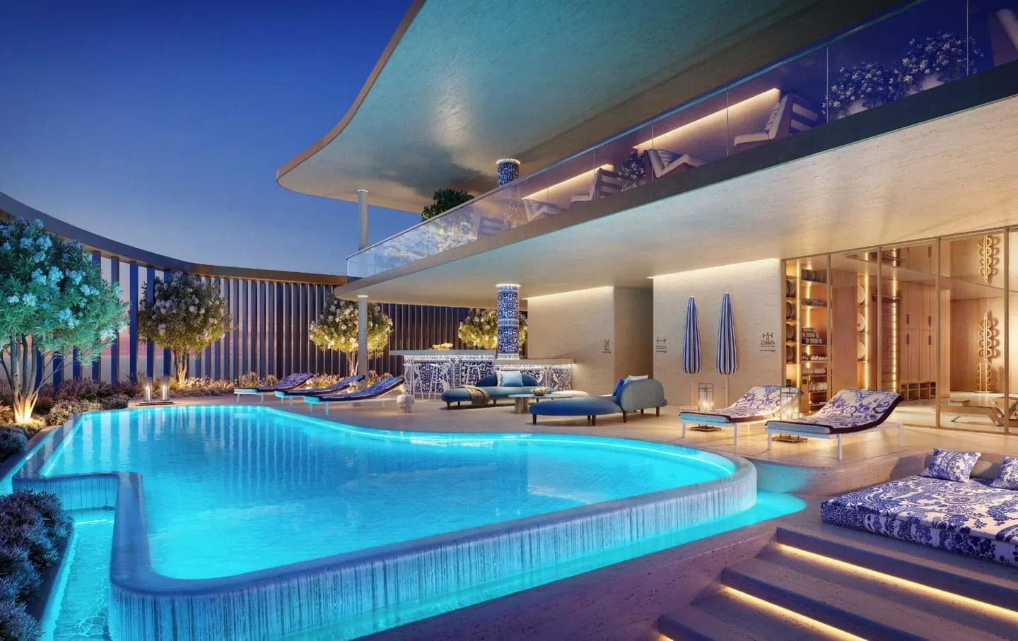 The pool lit at night, loungers on the deck and a bar counter under the projecting slab