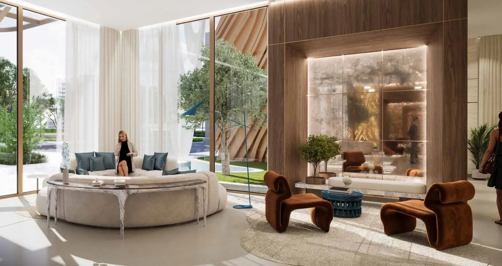 The residents' lounge, a curved sofa on a rug between stone columns with full height glazing behind
