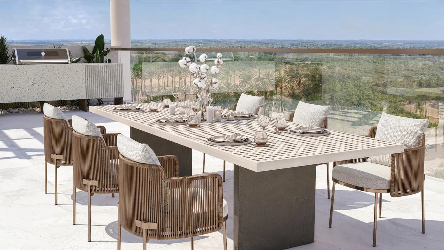 A long dining table set on the rooftop terrace under a pergola, open land stretching to the horizon at dusk