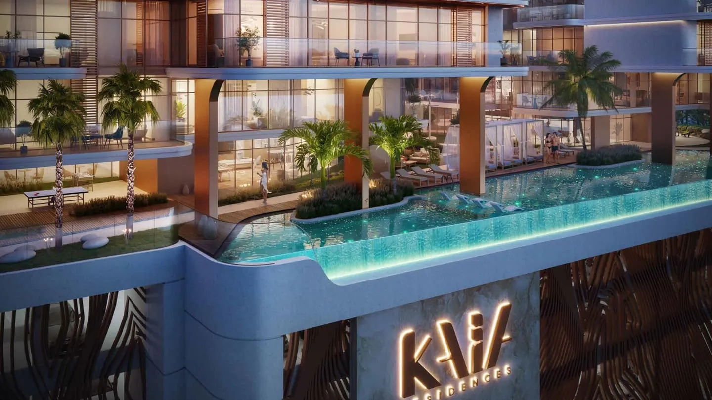 A pool at roof level running to the edge of the deck, balconies rising behind it and the Kaia sign on the wall below
