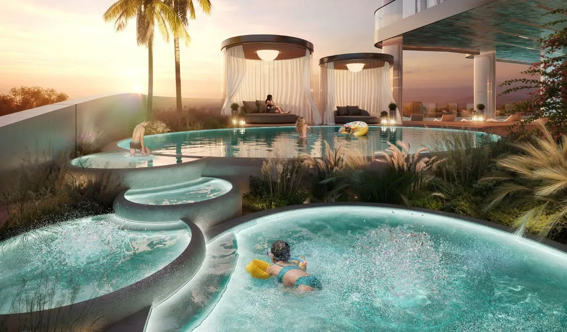 Circular rooftop tubs at sunset, bathers in the water with palms and drum-shaped cabanas behind them