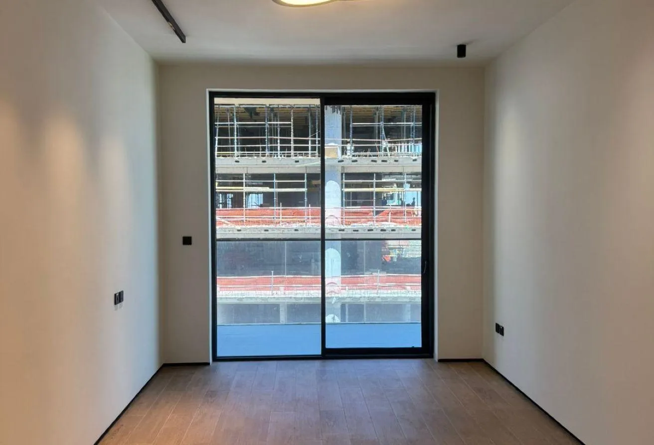 Photo of an empty room with a sliding glass door onto the balcony