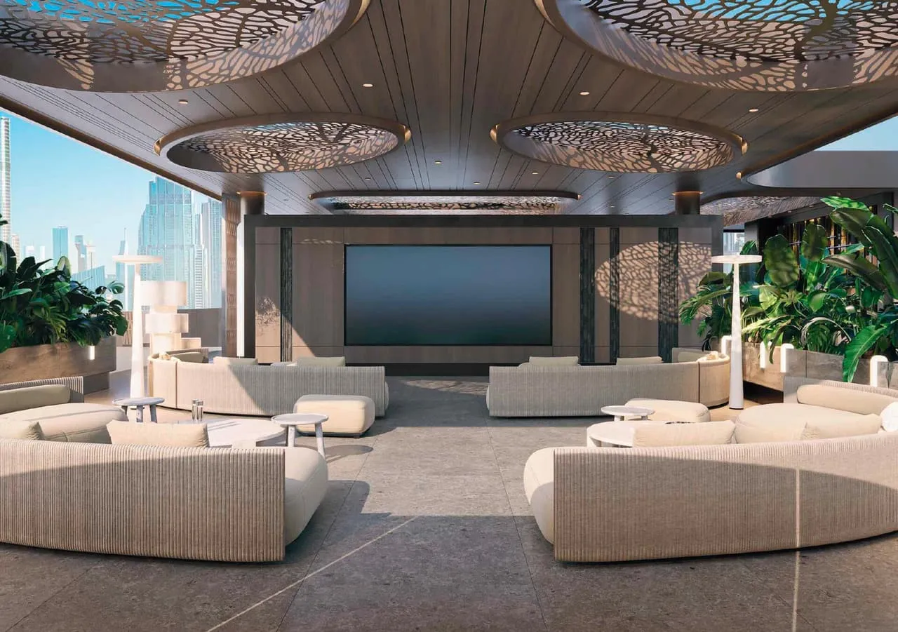 The screening lounge, deep sofas facing a wall mounted screen under a perforated ceiling