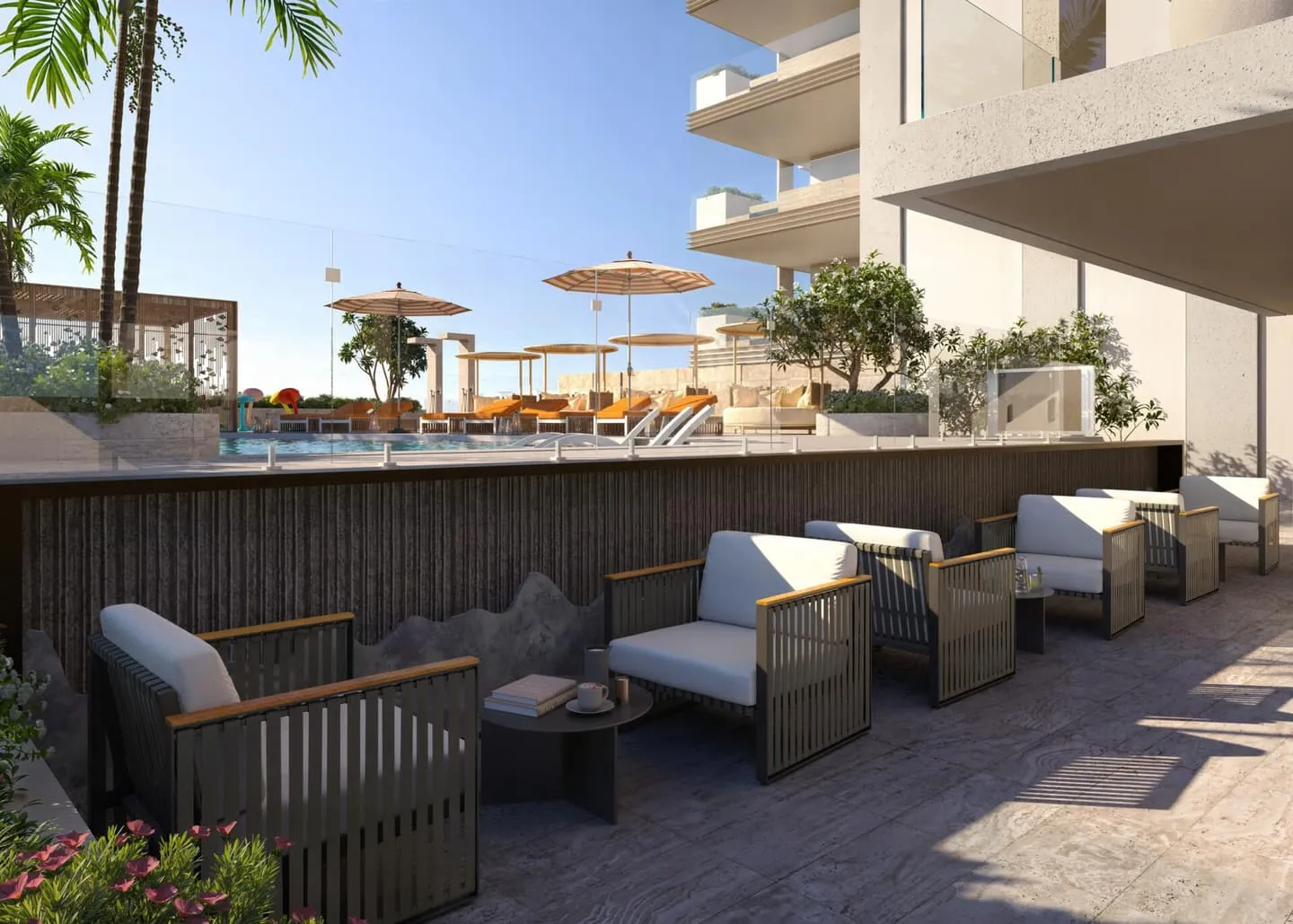 A shaded lounge terrace at the foot of the building, deep sofas and planters under the balconies above