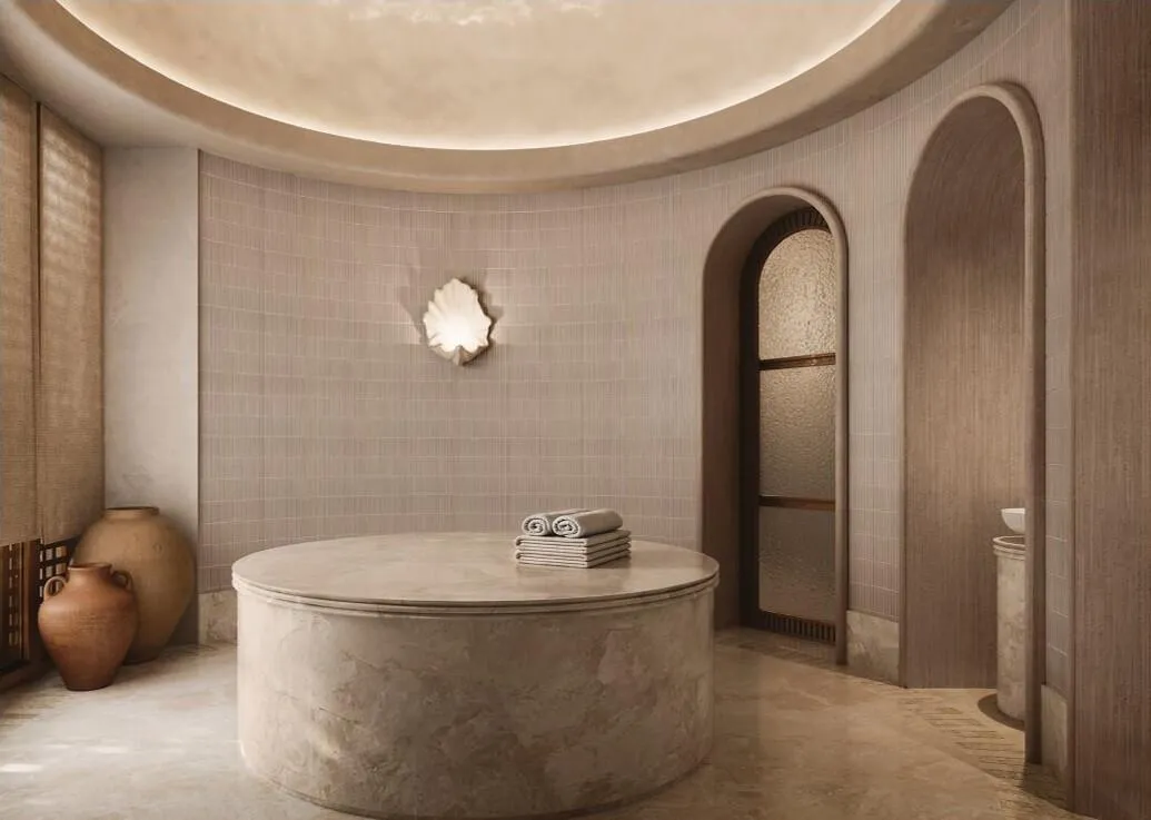 A spa room under a plaster dome, a stone bath in the centre and an arched doorway alongside