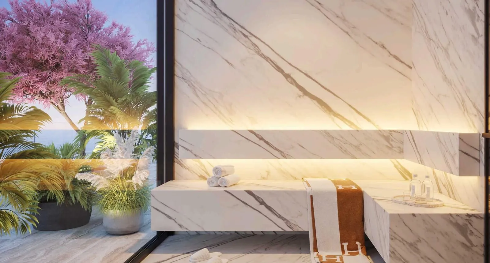 A treatment room in pale marble, the massage bed lit from beneath and a flowering tree at the window