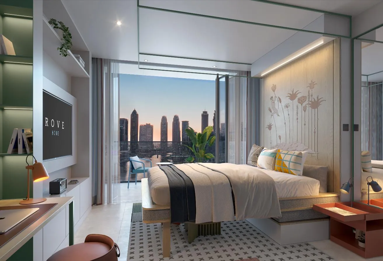 Render of the studio with a bed, a wall screen on the left and the skyline at sunset