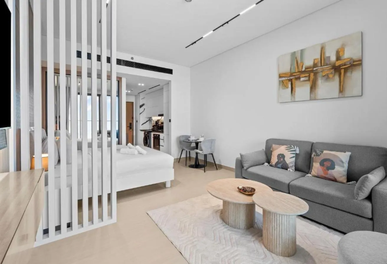 Photo of the studio, with the bed behind a slatted screen and a sofa in front