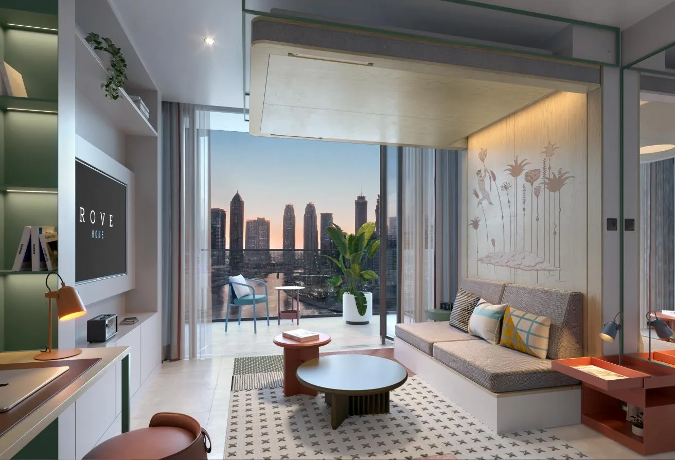 Render of the studio with a sofa and a round table, the wall screen on the left and the balcony beyond