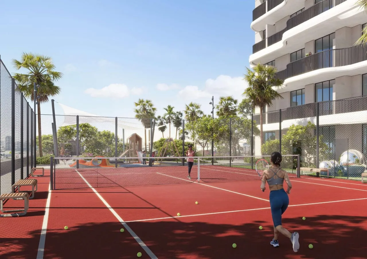 The tennis court in play, the building's curved facade rising directly behind it