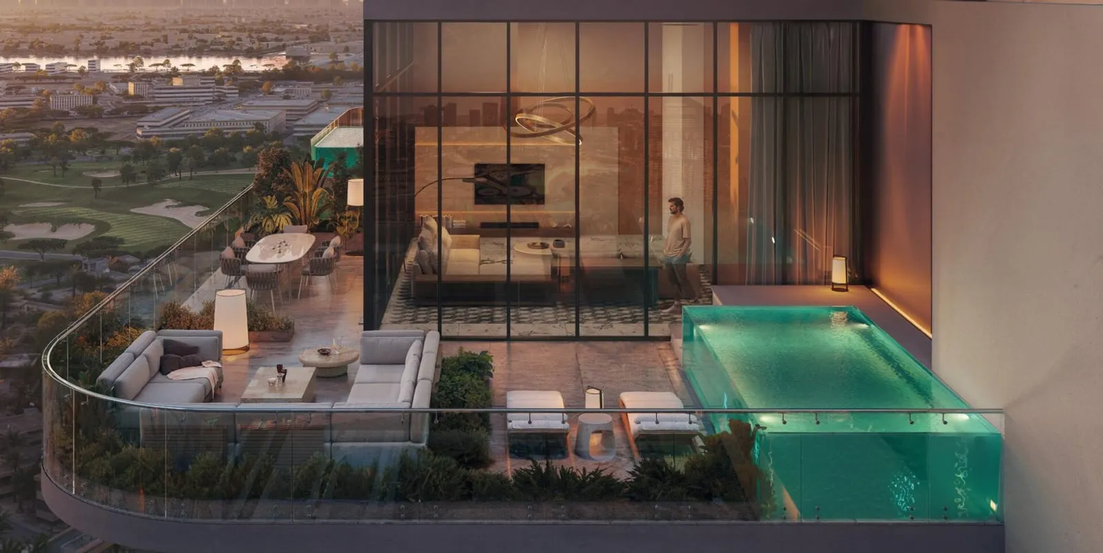 A terrace after dark, the plunge pool lit from within beside a sitting area open to the lit room
