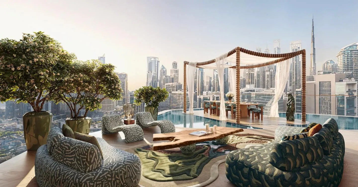 A terrace pool with low seating and planting around it, the skyline and the Burj Khalifa across the water