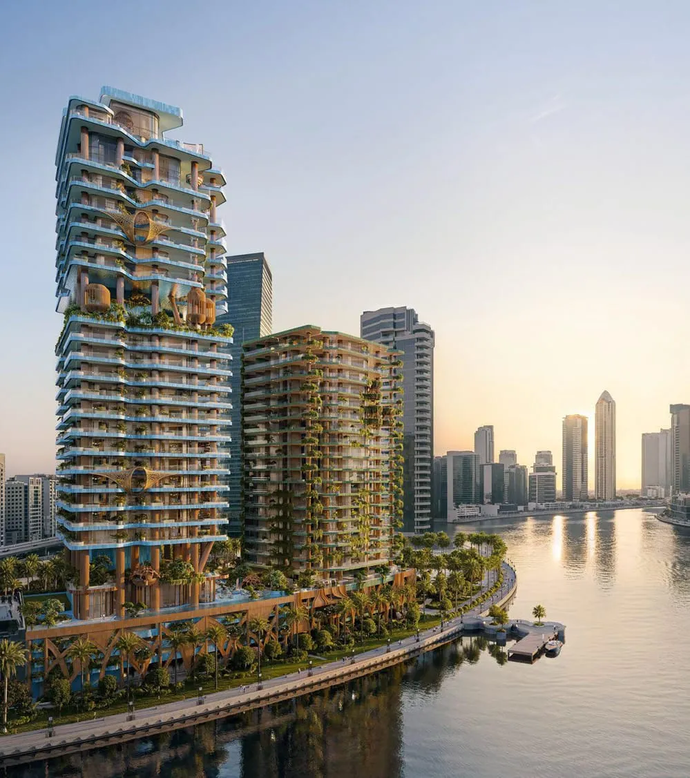 The tower at sunset above the canal, planted terraces backlit and the promenade running along the water below