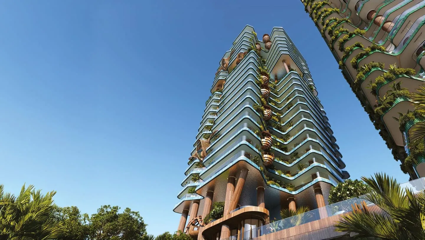Looking up the facade from the ground, curved balconies and their planting stacked against the sky between palms