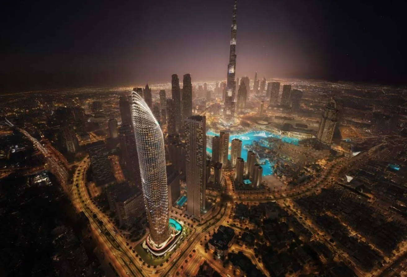 Render of Downtown Dubai at night from above, with the lit tower in the foreground and the Burj Khalifa behind