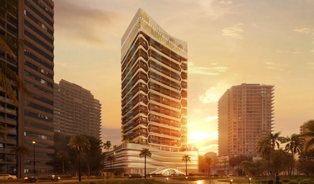 The building at sunset, the low sun behind a neighbouring block and the banded facade washed orange