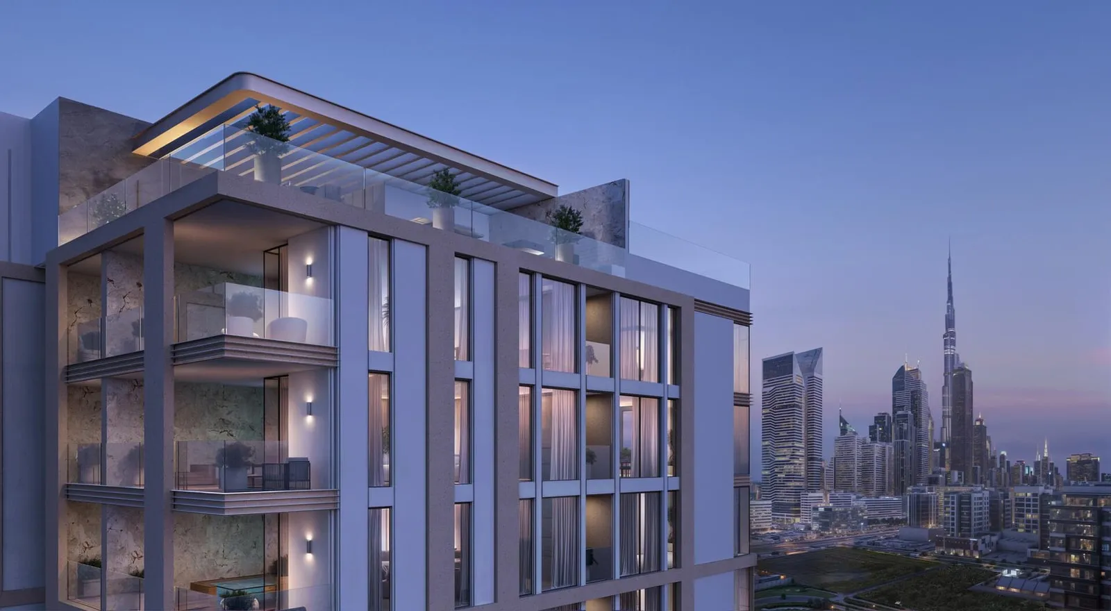 The upper floors at dusk, rooftop planting above the corner and Burj Khalifa small in the haze to the right