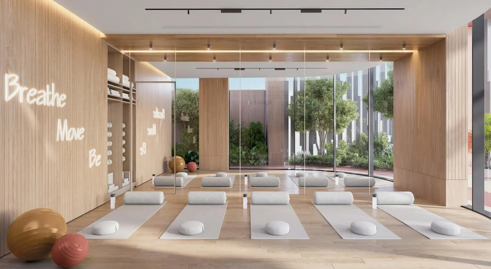 The yoga room, mats laid out in rows on a timber floor with exercise balls and lettering on the back wall